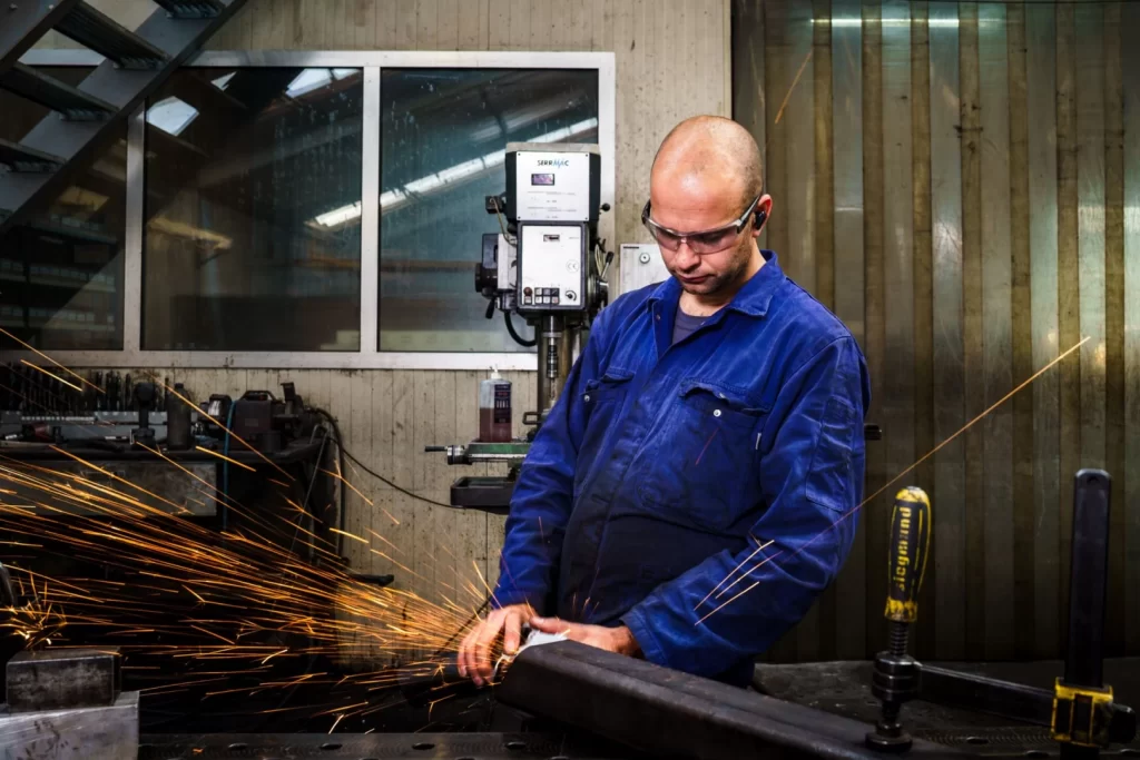 Medewerker van Elté Metaalbewerking slijpt een stalen profiel