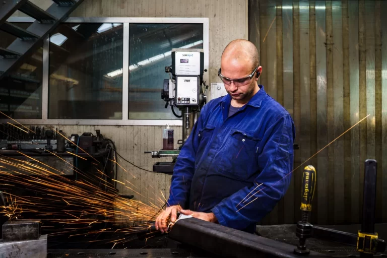 Medewerker van Elté Metaalbewerking slijpt een stalen profiel